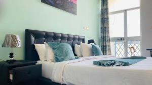 a bedroom with a large bed with blue pillows at Solkeb Hotel in Jijiga +2 photos