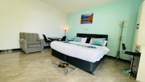 a bedroom with a large bed and a chair at Solkeb Hotel in Jijiga