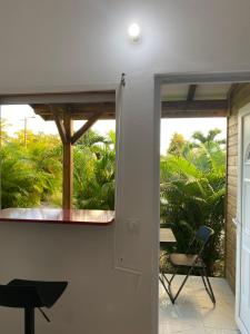 an open door to a patio with a table and chairs at Bungalow cerise in Morne-à-lʼEau