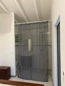 a shower with a shower curtain in a bathroom at Bungalow cerise in Morne-à-lʼEau