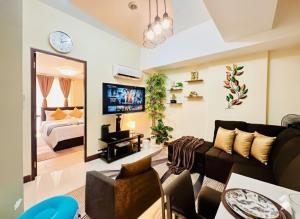 ein Wohnzimmer mit Sofa und Fernseher in der Unterkunft AdahkuMaya Luxury Suites in Manila