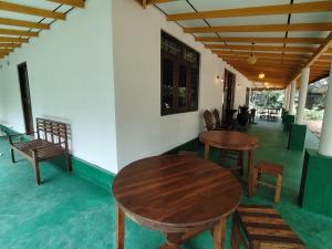 two wooden tables and chairs on a porch at Villa Hide Out in Busse
