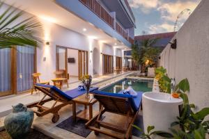 an outdoor patio with chairs and a swimming pool at Kubu YN Bali in Jimbaran