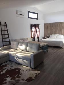 ein Wohnzimmer mit Sofa und Bett in der Unterkunft HOTEL RESTAURANT TURÓ de la TORRE in Manresa