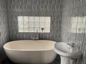 eine Badewanne und ein Waschbecken im Bad in der Unterkunft Edwin's Stay in Penebel