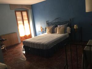 ein Schlafzimmer mit einem Bett mit einer blauen Wand in der Unterkunft HOTEL RESTAURANT TURÓ de la TORRE in Manresa