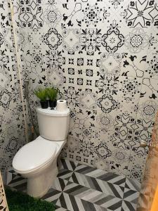 bagno con servizi igienici bianchi e piastrelle bianche e nere. di Xstaycation a Panglao