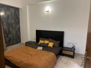 a bedroom with a bed with yellow pillows on it at north eye in Noida