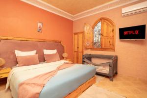 a bedroom with a bed and a tv on the wall at Villa Korima in Marrakesh +23 photos