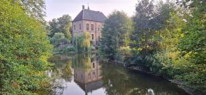 een oud gebouw wordt weerspiegeld in het water bij Berend 't Boerle in Vorden