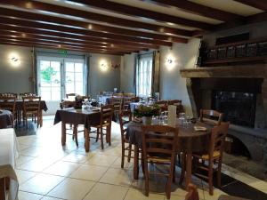 ein Esszimmer mit Tischen und Stühlen und einem Kamin in der Unterkunft Logis Hôtel Restaurant Auberge du Bougnat in St Victor la Riviere + 54 Fotos