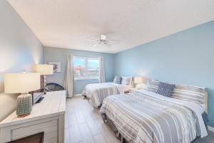 una camera da letto con due letti, una scrivania e una finestra di Beachfront Condo Sleeps 10 Heated Pool - 307 a St Pete Beach Altre 40 foto