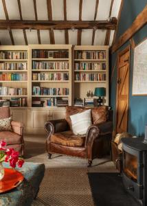 een woonkamer met een bank en boekenplanken bij Meadow End Barn in Dorstone