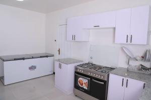 una cucina bianca con piano cottura e armadietti bianchi di Ethiopian, Addis Ababa ad Addis Abeba