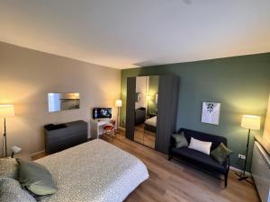 een slaapkamer met een bed, een bank en een spiegel bij Le due dimore di Corso Torino in Novara