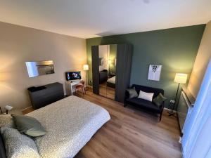 een slaapkamer met een bed, een bank en een spiegel bij Le due dimore di Corso Torino in Novara