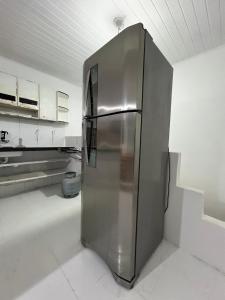 een roestvrijstalen koelkast in een witte keuken bij Casa das laranjeiras in Serra