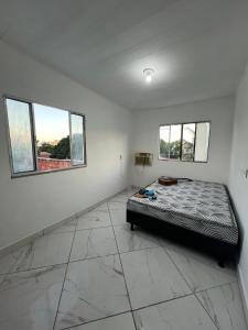 een slaapkamer met een bed en twee ramen bij Casa das laranjeiras in Serra