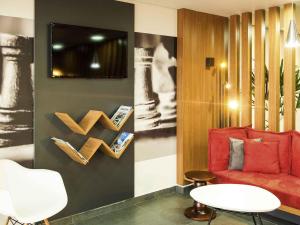 a living room with a red couch and a table at ibis Cascavel in Cascavel