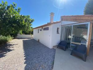 a house with two blue chairs in front of it at Mas de la Vieille Vigne in Argelès-sur-Mer