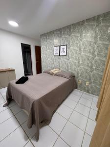 una camera da letto con un letto e un pavimento piastrellato di Ap 1km da praia Araçagi a São Luís