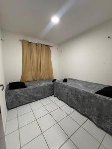 een kamer met 2 bedden en een raam erin bij Ap 1km da praia Araçagi in São Luís