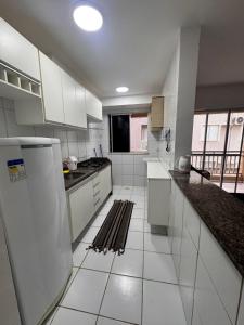 een witte keuken met witte apparatuur en een groot raam bij Ap 1km da praia Araçagi in São Luís