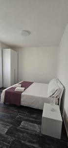 a white bedroom with a bed and a table at Step by step in Scalea