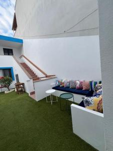 eine Terrasse mit einem Sofa und Stühlen auf dem Rasen in der Unterkunft KE Urla in Urla