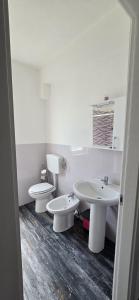 ein weißes Badezimmer mit 2 WCs und einem Waschbecken in der Unterkunft Step by step in Scalea + 10 Fotos
