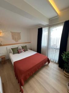ein Schlafzimmer mit einem großen Bett und einem großen Fenster in der Unterkunft KE Urla in Urla