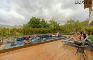 eine Gruppe von Personen in einem Pool in einem Resort in der Unterkunft EKOSTAY - Amani Villa in Khopoli