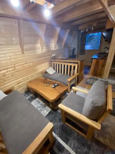 een kamer met banken en tafels in een cabine bij Planinska Vikendica SP Jahorina in Bistrica