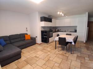 een woonkamer met een bank en een tafel en een keuken bij Appartamento a Dimaro in Val di Sole in Monclassico