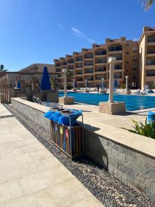 un bidone della spazzatura appoggiato accanto a un muro vicino a una piscina di Selena bay hurghada a Hurghada