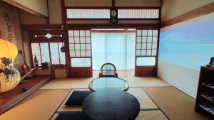天草市Minpaku Jaito-民泊じゃいと-Homestay in Traditional House的一间设有玻璃桌和椅子的房间