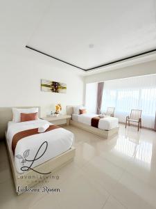 een slaapkamer met twee bedden en een tafel en stoelen bij Lavani Living Hotel in Tjakranegara