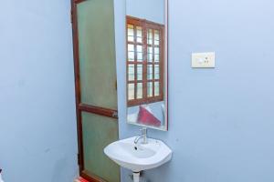 a bathroom with a sink and a mirror at Greens Heritage Resort with Swimming Pool in Auroville