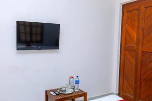 a living room with a tv and a table at Greens Heritage Resort with Swimming Pool in Auroville