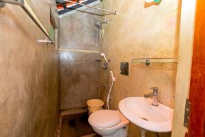 a small bathroom with a toilet and a sink at Greens Heritage Resort with Swimming Pool in Auroville +180 photos