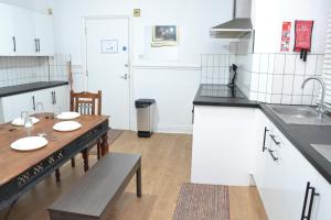 - une cuisine avec une table en bois, un évier, une table et une table dans l'établissement Manchester Ashton Suites, à Ashton-under-Lyne