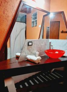 ein Badezimmer mit einem roten Waschbecken und einem Spiegel in der Unterkunft Tere & Tino Cabañas in Río Ceballos
