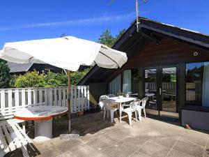 een patio met een parasol en een tafel en stoelen bij 8 person holiday home in Løgstør-By Traum in Løgstør