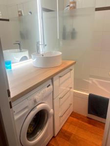 a bathroom with a washing machine and a sink at Appartement Pyla Les Cèdres in Pyla-sur-Mer +38 photos