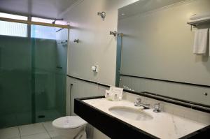 a bathroom with a sink and a shower and a toilet at Jandaia Hotel Campo Grande in Campo Grande