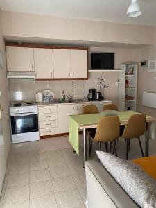 a kitchen with a table and chairs and a kitchen with a stove at Feels like home 2 in Maniákoi