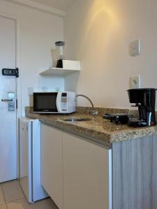 een keuken met een aanrecht met een magnetron bij Studio vista panorâmica completo in Macaé