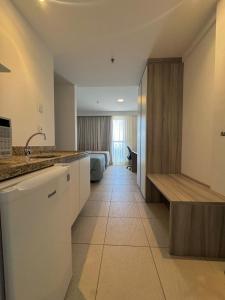 een keuken met een wastafel en een bed in een kamer bij Studio vista panorâmica completo in Macaé +10 foto's