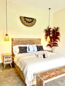 a bedroom with a large bed with black and white pillows at Villa Santé ubud in Ubud