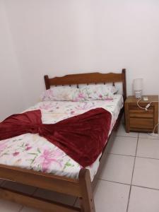 a bed with a red blanket on it in a room at Cassiane Apartments in Thibaud